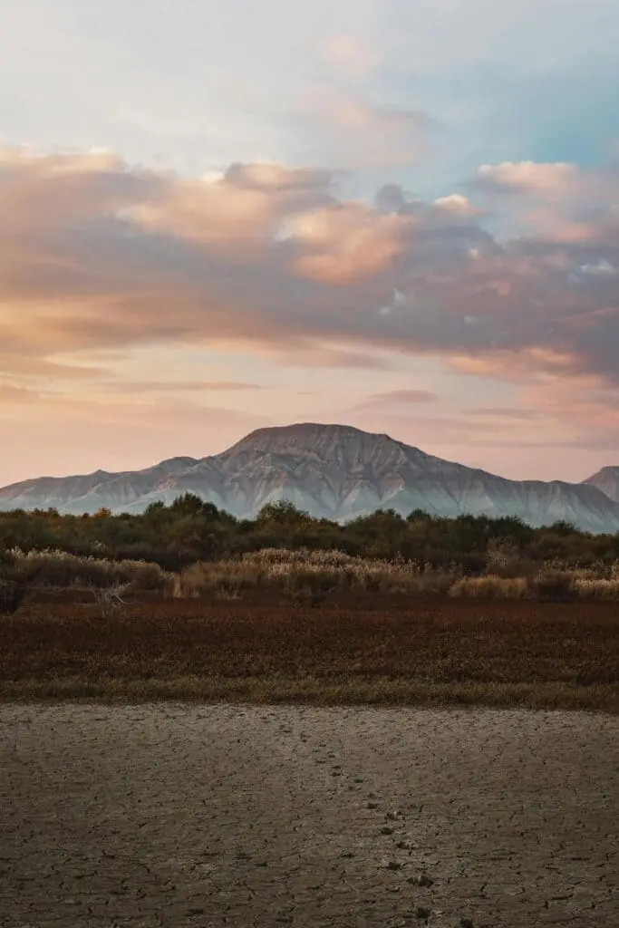 Mountain landscape and open land at sunset highlighting key considerations before selling rural property or vacant land