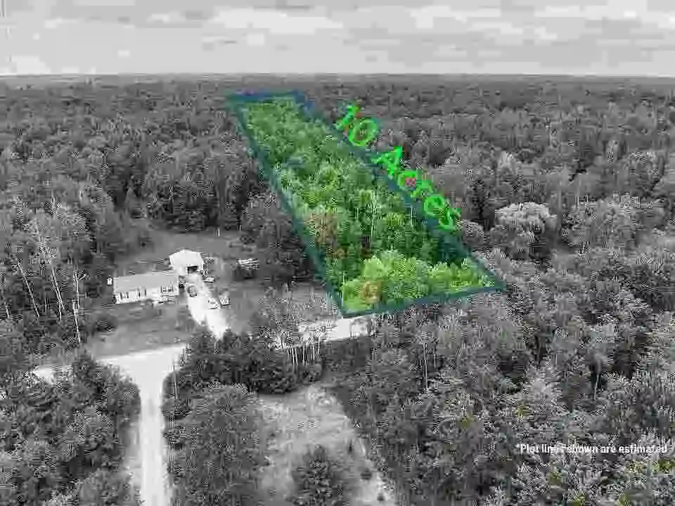 Aerial view of 10 acre land parcel outlined in forest with nearby house and road access